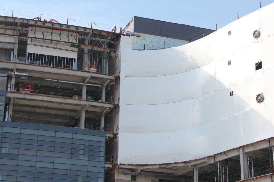 building under construction with dust containment wrap on exterior
