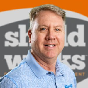 man in blue polo with shieldworks logo background