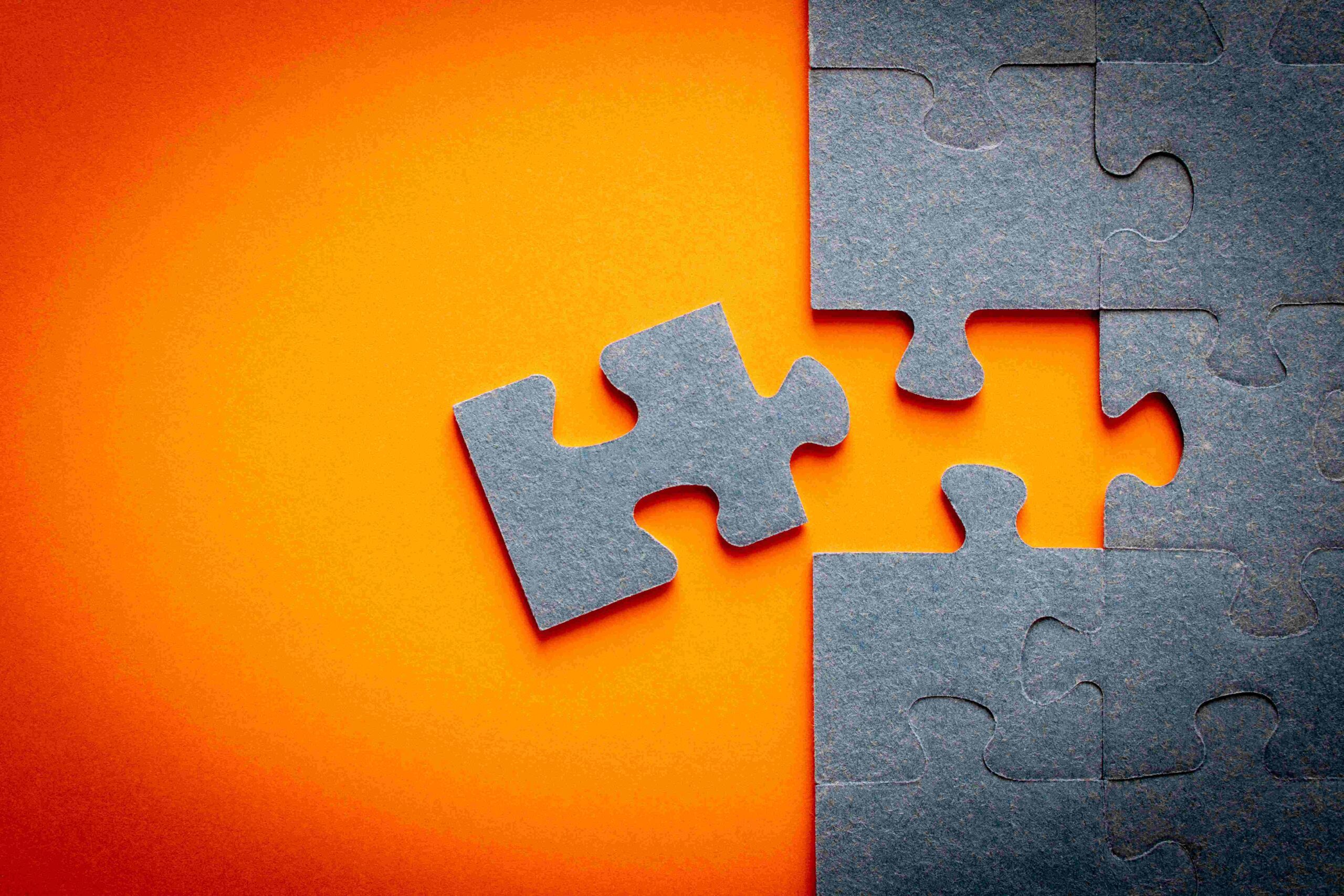 orange background with grey felt puzzle pieces